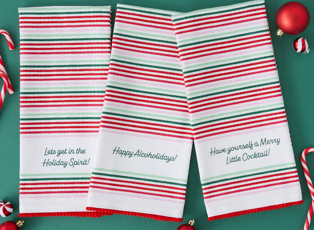Three striped towels with humorous holiday sayings on a green background.